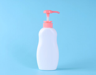 Blank label bottle of antibacterial liquid soap and hand sanitizer mockup on blue background. White unbranded dispenser bottle isolated on blue background. Hygiene product and health care.