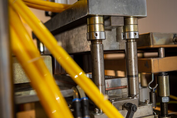 Focus on the hydraulic press on the plastic packaging machine. Industry. Packaging.