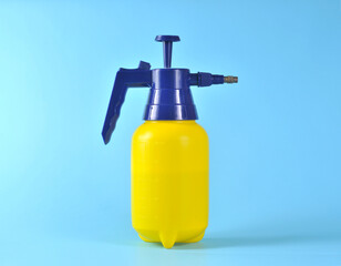 Spray bottle on blue background. Portable pressure water sprayer pump. Sprayer bottle.
