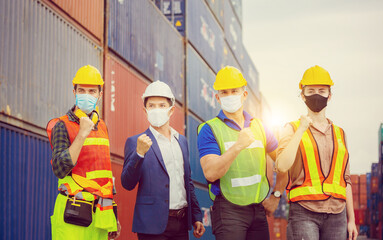 Success and Teamwork Concept, Engineer and worker team wearing protection face mask against coronavirus, Happy business people team celebration with blurred cargo containers background