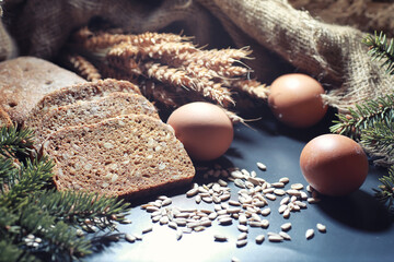Fresh loaves of bread with wheat and gluten on a black table. Bakery and grocery concept. Fresh,...