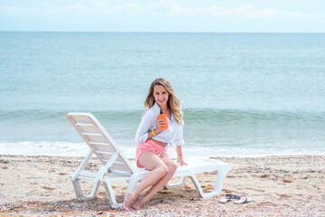 woman sitting on the beach with laptop. young woman relaxing on the beach. 
Beautiful woman on the beach is smeared with sunblock. Rest and relaxation. Travel to the sea