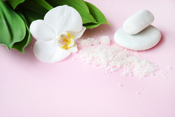 Fototapeta na wymiar Flat lay composition with white spa sea salt and white orchid with space for text on pink background. Spa cosmetic and Beauty concept, top view. Meditation and minimalism. copyspase flatlay.