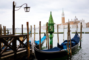 Obraz na płótnie Canvas Venice, Italy - August 25, 2018. Gondolas at the pier overlooking the San Giorgio Maggiore. Gondolas at the pier in Venice.