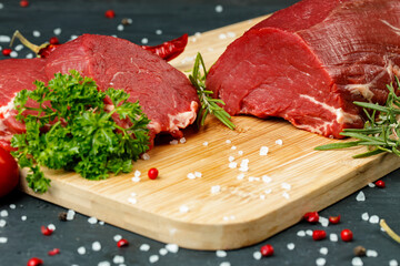 Slice of raw beef fillet on wooden board