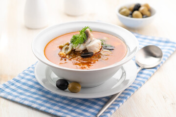 Fish soup with vegetables lemon and olives.