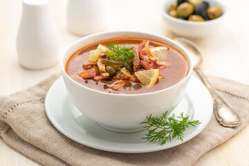 Meat soup with vegetables and olives.