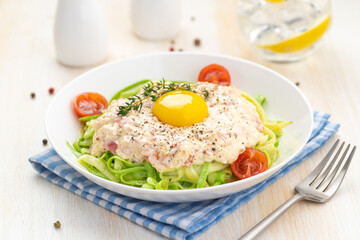 Traditional dish of Italian cuisine carbonara sauce with low-carb zucchini paste and egg yolk.