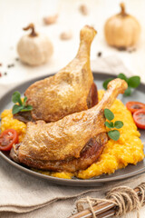 Roasted duck leg with pumpkin puree and fresh herbs.