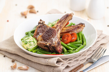 Grilled lamb chops with a garnish of green beans and fragrant butter.