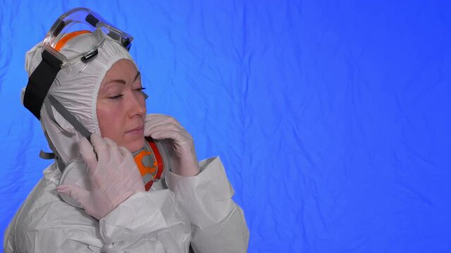 Scientist virologist in respirator. Slow motion. Woman close up look wearing protective medical mask. Concept health safety N1H1 virus protection coronavirus epidemic 2019 nCoV. Chroma key blue film.