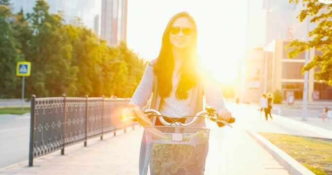 Modern city eco lifestyle, girl in sunglasses rides old vintage bicycle