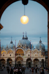 Tourists in the square in front of St. Mark's Cathedral in the evening. St. Mark's Basilica in the evening,Venice, Italy.