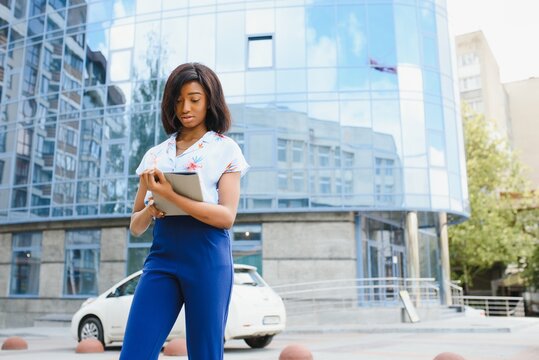 Beautiful Black Woman Using Tablet Computer In Urban Background. Successful Woman Concept.