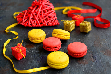 Composition of multi-colored macaroons and ribbons on a dark blue background. Holiday Concept