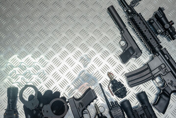 Special agent equipment on the metal table with copy space concept. Airsoft weapon background.