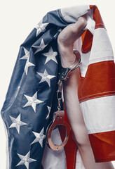 hands on a white background clenched into a fist with handcuffs fastened on it, hands clutch the...