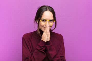 young pretty woman happy and excited, surprised and amazed covering mouth with hands, giggling with...