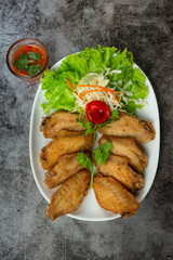 Fried wings with fish sauce, beautifully decorated herbs and served.