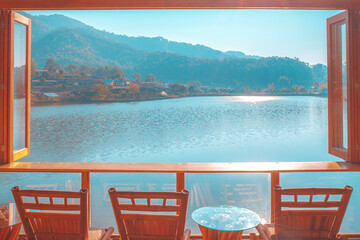 Window of coffee open to lake or river water at the morning with landscape pfoto of valley of village of the mountain.
