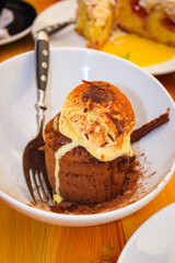 Very Delicious Italian Desserts On A White Plate On A Wooden Table With A Fork