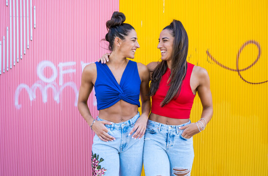 twins in front of pink and yellow wall