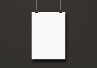 White poster hanging on a black wall with clips
