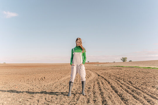 Young woman standing on dry field