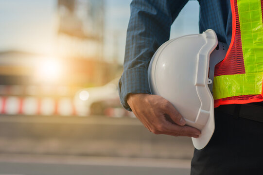 Close Up Hand Holding White Helmet Hard Hat Engineering Concept,Technician Holding White Hat Safety Hard Hat Sunlight Background
