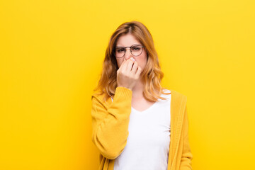 young pretty blonde woman feeling disgusted, holding nose to avoid smelling a foul and unpleasant...