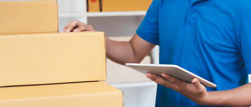 The shipping company checking parcels list before delivering to customers
