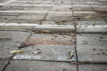 Broken concrete pathway brick surface background, close up abstract cracked cement block texture. Gray floor..