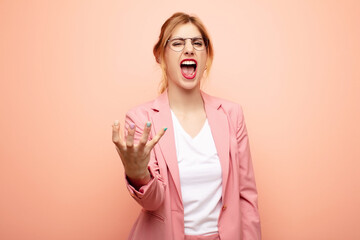 young pretty blonde woman looking angry, annoyed and frustrated screaming wtf or what‚Äôs wrong...