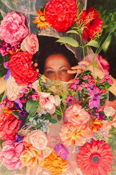 Beautiful woman looking through veil with flowers
