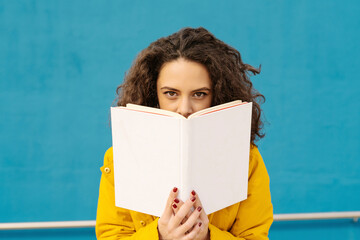 Portrait of young woman woman in front of blue wall