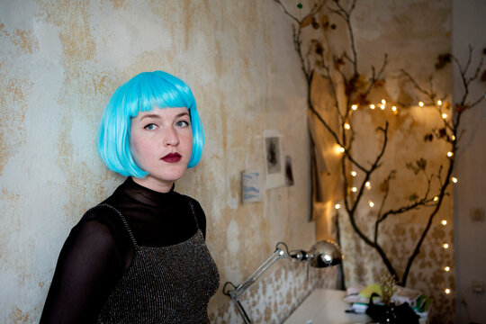 Young woman wearing blue wig
