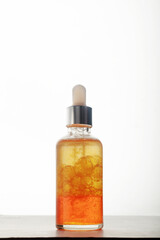 frasco de vidrio con gotero sobre fondo blanco al trasluz