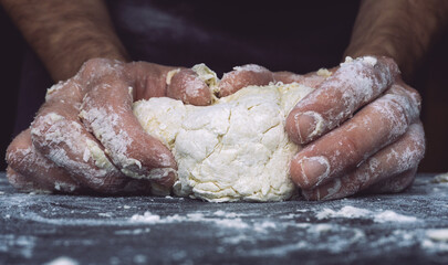 Dough pizza background. Hands prepare dough for pizza or bread on the kitchen table.
