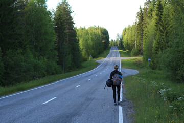 hitch-hiking girl walking on the road