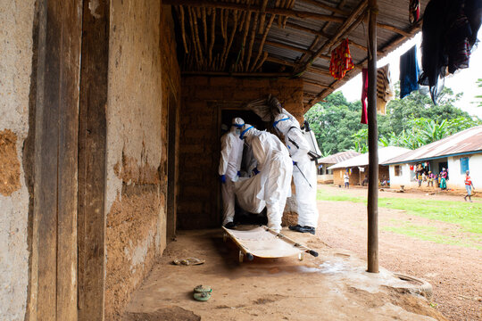 Lunsar, Sierra Leone, June 24, 2015: the burial team takes a dead person from the interior of a house. ebola response epidemic disease in Africa, ebola and corona virus context. Editorial use