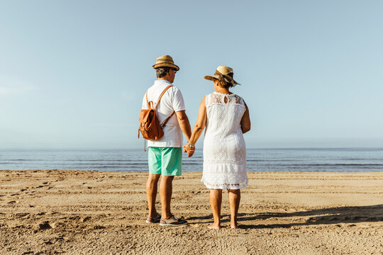 Rear view of senior couple on the beach, El Roc de Sant Gaieta, Spain