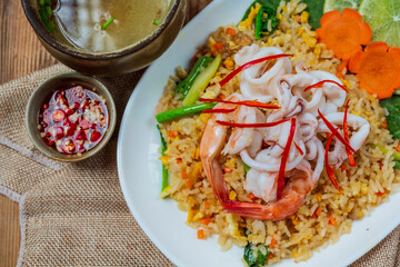 Delicious seafood fried rice with shrimp, eggs and spring onions with soup.