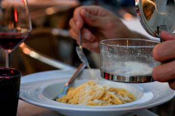 Bowl of pasta with Parmesan and glass of wine