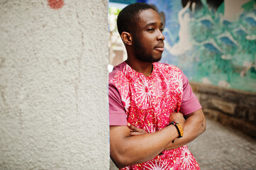 Obraz premium Portrait of a black young man wearing african traditional red colorful clothes.