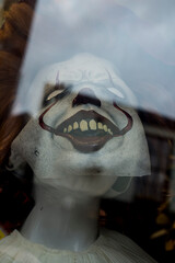 A clown mask in a fancy dress shop laughing and looking evil on halloween