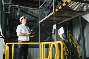 happy male industrial technician inside a factory