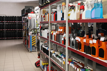 Shelves with car care products and tires in auto store