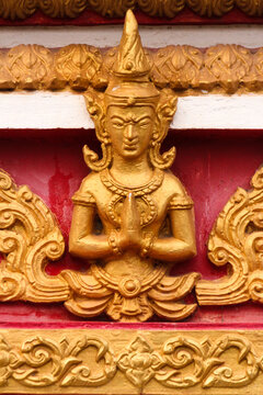 Praying buddha image as golden stupa decoration in a temple and religious site in Siamese Lao PDR, Southeast Asia
