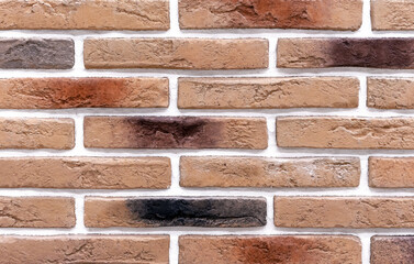 Brick wall of beige and brown bricks. Background and texture of brickwork.