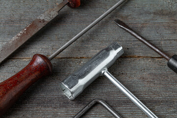 Chainsaw maintenance tools on a wooden table. Combination socket tool, rasp, screwdriver.